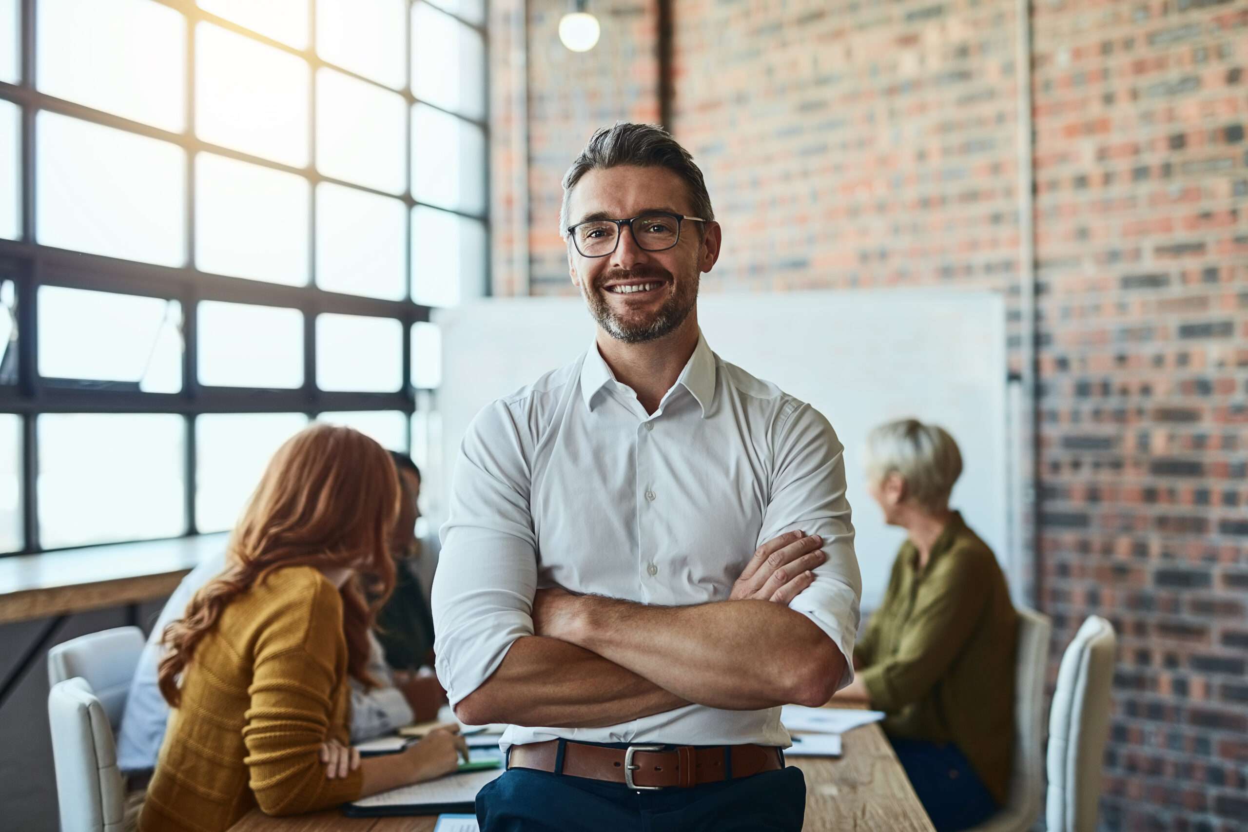 Our business is built on confidence. Cropped shot of a businessman standing in the office with his arms folded looking confident and smiling at the camera.